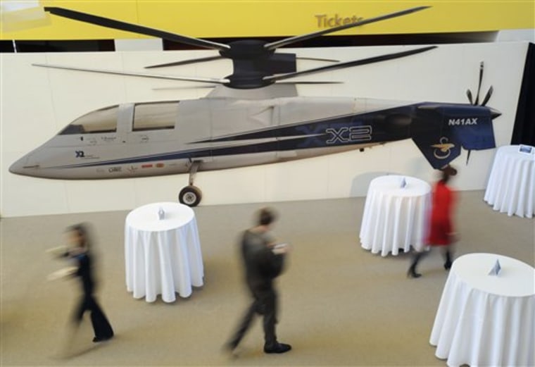Attendees of a news event launching Sikorsky Aircraft Corporation's new technology creation business, Sikorsky Innovations, walk past a model of the Sikorsky X2 technology demonstrator aircraft in Hartford, Conn., on Monday, Feb. 1, 2010.